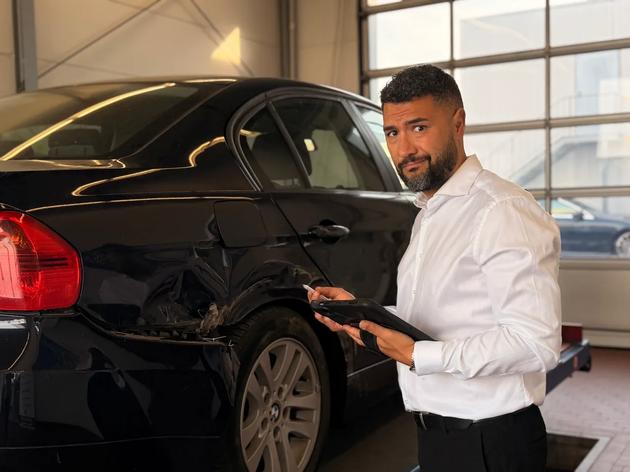 KAVA-Gutachter mit Tablet neben einem Fahrzeug